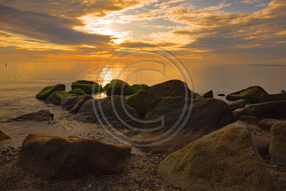 Stunning sunrise with rocks and beach Cape Cod Bay